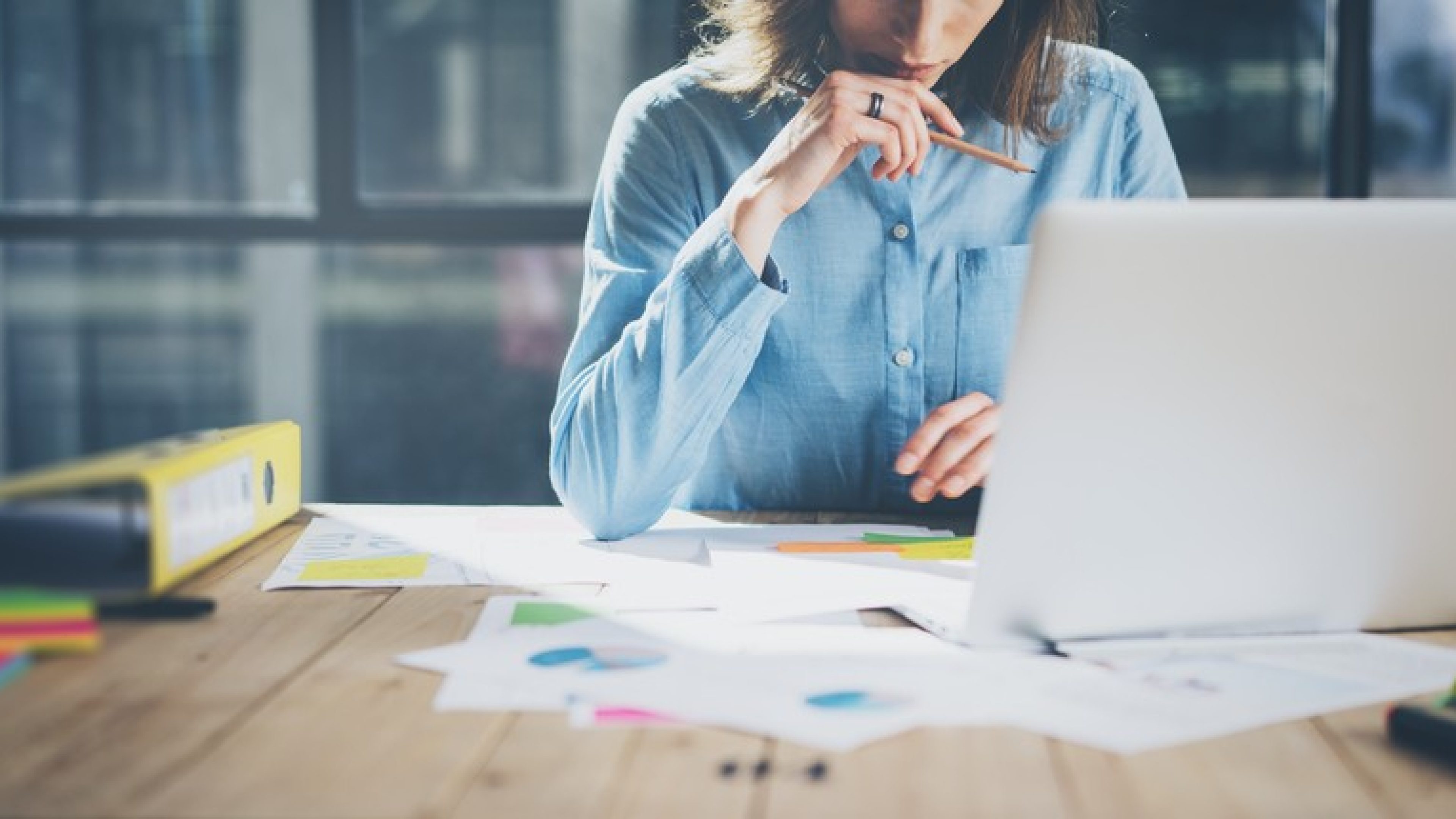 Young architect working project. Photo young woman working with new startup project in modern loft. Generic design notebook on wood table. Horizontal