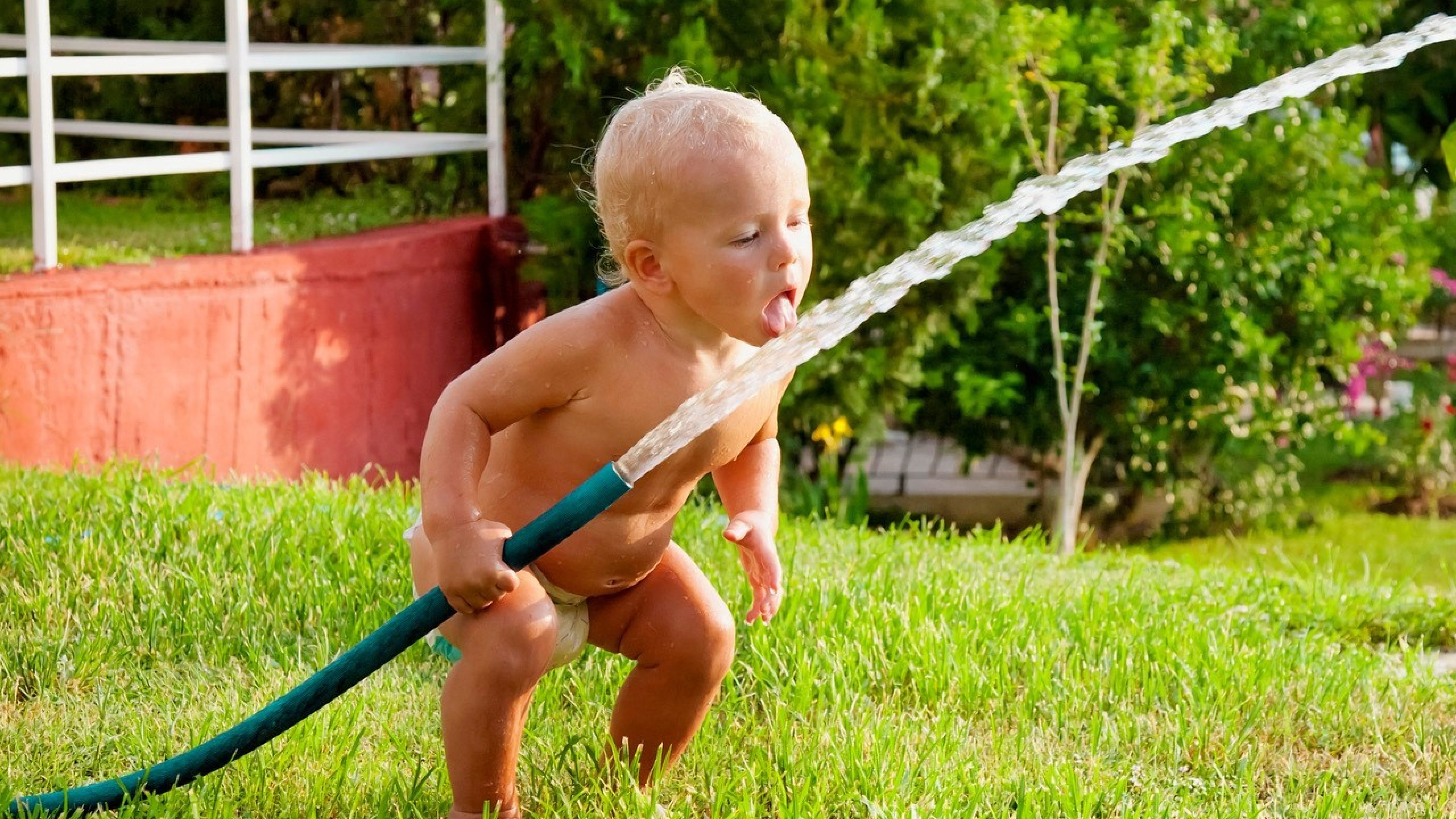 baby mit wasserschlauch