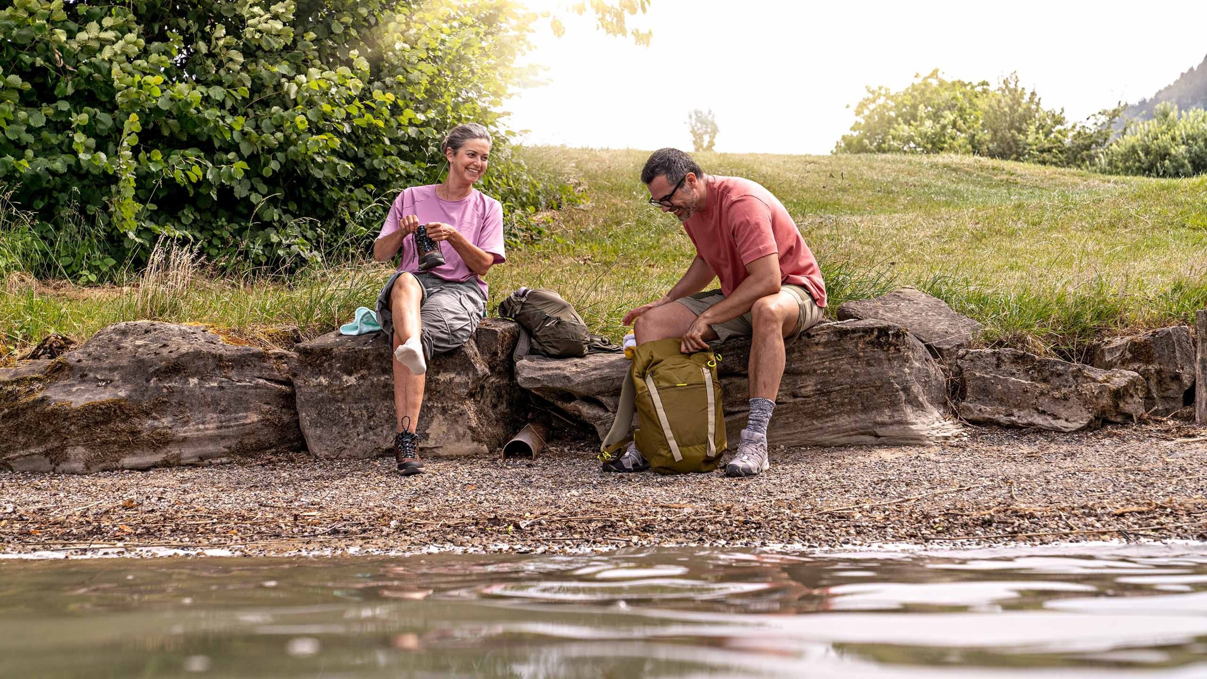 A couple on a hike take a break at the lake.